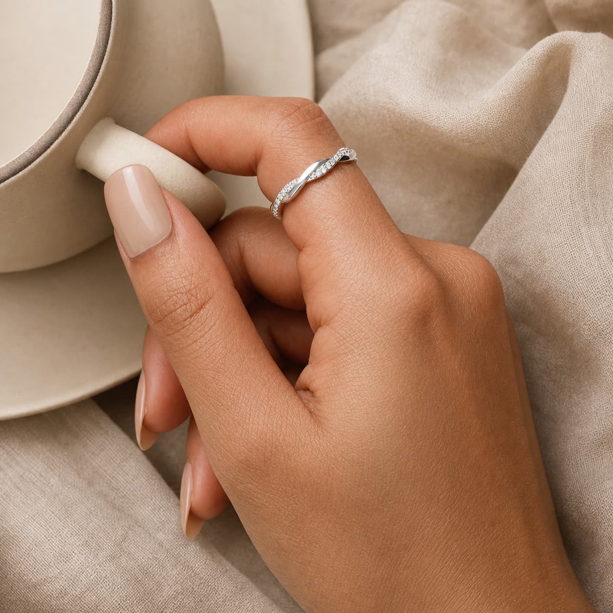 Light-finish wave ring worn on hand in natural light